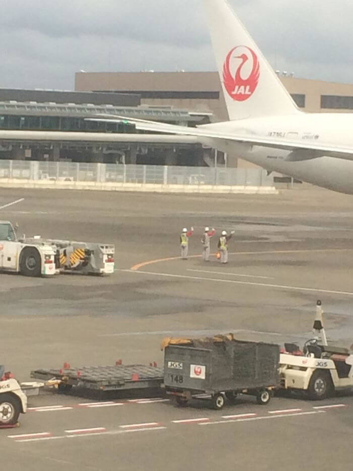 日本の仕事人たちは、出発する飛行機と乗客に手を振る